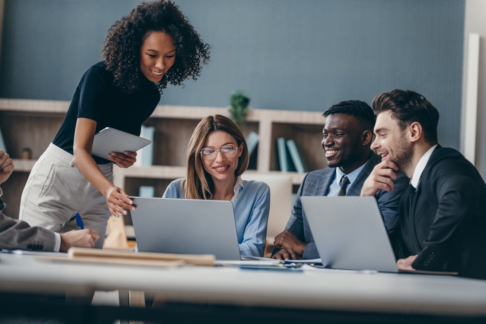 A diverse team collaborating on cluster development strategies, using technology and teamwork to drive business growth.