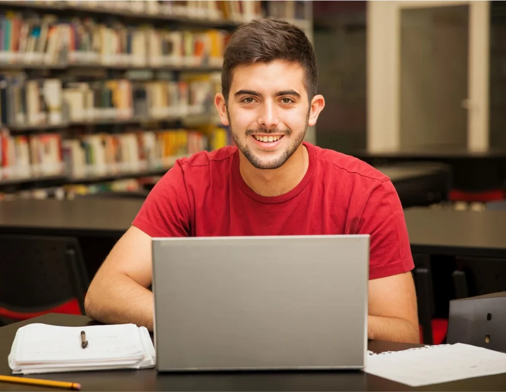 male student smiling at camera in library